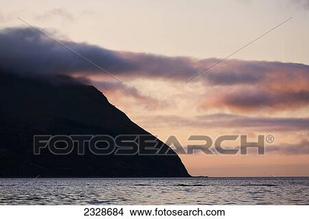 Picture - Clouds Colored By The Setting Sun Near King Cove, Alaska Peninsula; Southwest Alaska, United States Of America. Fotosearch