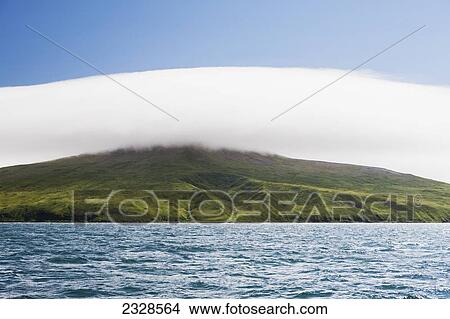 Picture - Clouds Hovering Over Green Shores Near Cold Bay, Alaska Peninsula; Southwest Alaska, United States Of America. Fotosearch