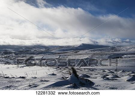 Stock Image - Clouds sweeping over upper Wensleydale hills following a snow storm; Wensleydale, Yorkshire, England. Fotosearch