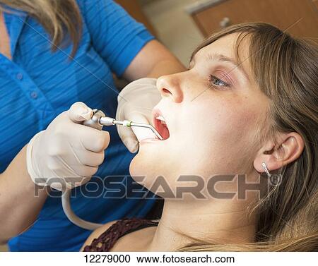 Dental assistant performing dental procedure on female patient; Edmonton, Alberta, Canada View Large Photo Image Stock Image - Dental assistant performing dental procedure on female patient; Edmonton, Alberta, Canada. Fotosearch