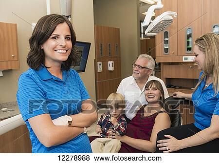 Stock Photo - Dentist with two assistants completing a consultation with mother and son patients; Edmonton, Alberta, Canada. Fotosearch