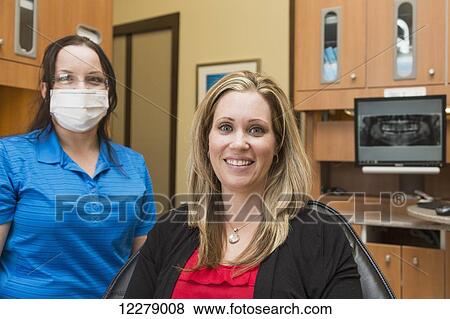 Female patient posing before dental exam performed by dental assistant; Edmonton, Alberta, Canada View Large Photo Image Stock Photo - Female patient posing before dental exam performed by dental assistant; Edmonton, Alberta, Canada. Fotosearch