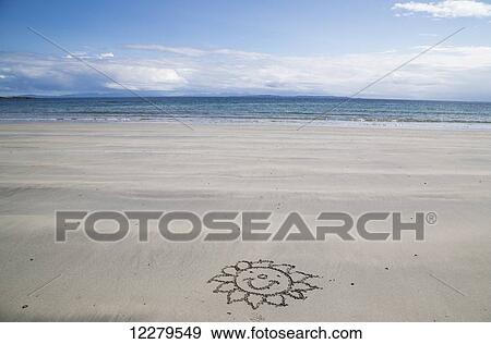 Stock Photo - Flower with happy face drawn in the sand on the beach; Isle of Mull, Arygll and Bute, Scotland. Fotosearch