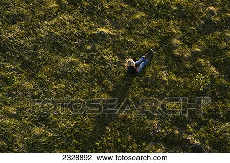 High Angle View Of A Girl Sitting In A Grass Field; False Pass, Alaska, United States Of America View Large Photo Image Stock Image - High Angle View Of A Girl Sitting In A Grass Field; False Pass, Alaska, United States Of America. Fotosearch