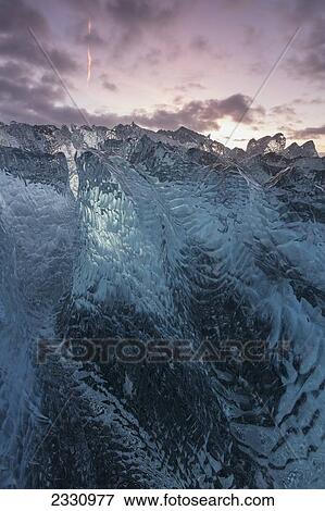 Stock Photo - Iceberg On The Beach Along The South Coast Of Iceland With The Sunrise Colours Above It; Iceland. Fotosearch