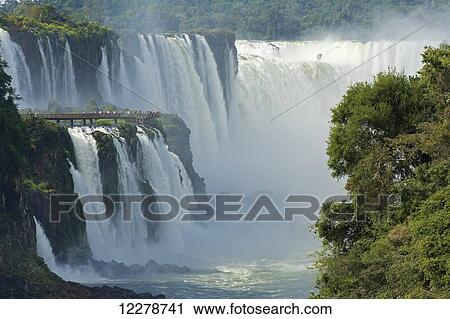 Stock Image - Iguazu Falls with tourists on a walkway; Argentina. Fotosearch