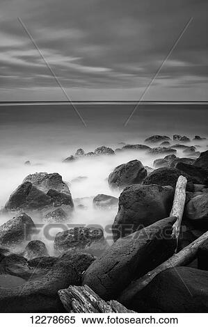 Stock Photography - Long exposure of the surf along Wailua Beach processed in high contrast black and white; Wailua, Kauai, Hawaii, United States of America. Fotosearch