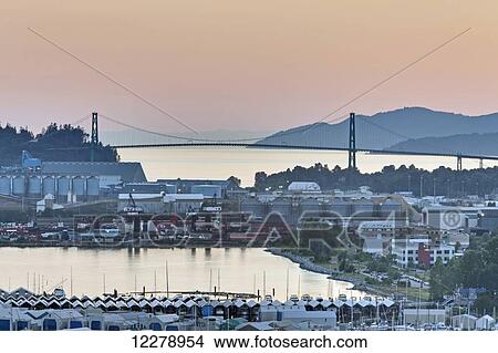 Picture - Looking west towards West Vancouver, Bowen Island and the Lions Gate Bridge in the late afternoon sun at North Vancouver; Vancouver, British Columbia, Canada. Fotosearch