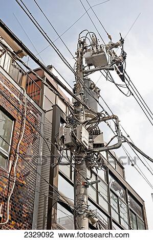 Stock Image - Low Angle View Of Transmission Boxes And Wires Beside A Building; Tokyo, Japan. Fotosearch