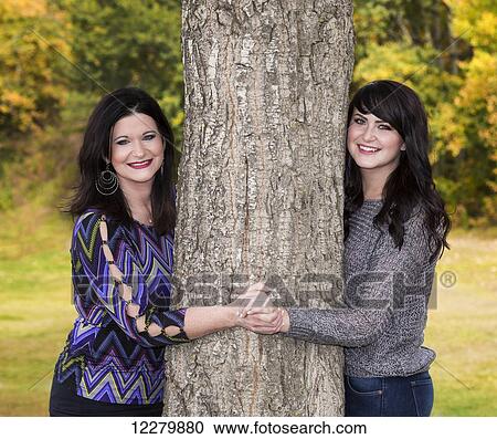 Mother and daughter posing and spending quality time together in a city park in autumn; St. Albert, Alberta, Canada View Large Photo Image Stock Image - Mother and daughter posing and spending quality time together in a city park in autumn; St. Albert, Alberta, Canada. Fotosearch
