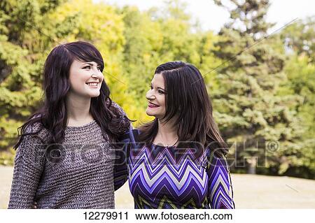 Mother and daughter spending quality time together outdoors in a park in autumn; St. Albert, Alberta, Canada View Large Photo Image Stock Image - Mother and daughter spending quality time together outdoors in a park in autumn; St. Albert, Alberta, Canada. Fotosearch