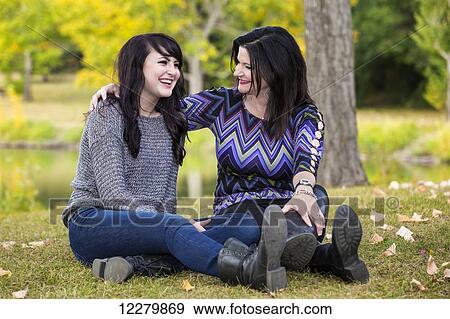 Stock Photo - Mother and daughter spending quality time together outdoors in a city park in autumn; St. Albert, Alberta, Canada. Fotosearch