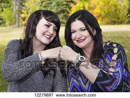 Mother and daughter spending quality time together outdoors in a city park in autumn; St. Albert, Alberta, Canada View Large Photo Image Stock Photo - Mother and daughter spending quality time together outdoors in a city park in autumn; St. Albert, Alberta, Canada. Fotosearch