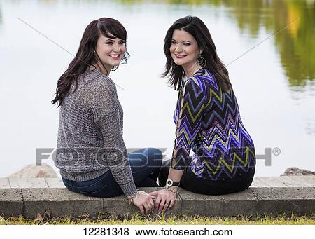 Stock Photo - Mother and daughter spending quality time together outdoors in a city park in autumn; St. Albert, Alberta, Canada. Fotosearch