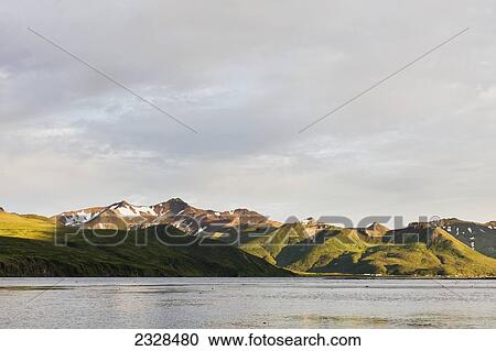 Mountains And A Town Along The Coastline On Unimak Island; False Pass, Alaska, United States Of America View Large Photo Image Stock Image - Mountains And A Town Along The Coastline On Unimak Island; False Pass, Alaska, United States Of America. Fotosearch