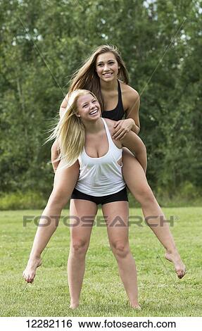 One girlfriend giving the other girlfriend a piggy back ride in a park; Edmonton, Alberta, Canada View Large Photo Image Stock Photograph - One girlfriend giving the other girlfriend a piggy back ride in a park; Edmonton, Alberta, Canada. Fotosearch