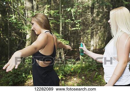 One teenage girl applying insect repellent to the other girlfriend in a park; Edmonton, Alberta, Canada View Large Photo Image Stock Photo - One teenage girl applying insect repellent to the other girlfriend in a park; Edmonton, Alberta, Canada. Fotosearch