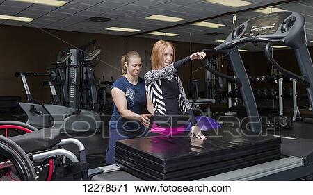 Physiotherapist assisting young woman with spinal cord injury in performing high kneeling balance exercises; Edmonton, Alberta, Canada View Large Photo Image Stock Image - Physiotherapist assisting young woman with spinal cord injury in performing high kneeling balance exercises; Edmonton, Alberta, Canada. Fotosearch