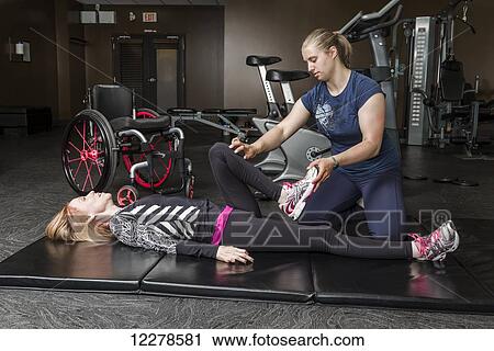 Physiotherapist assisting young woman with spinal cord injury in performing hip circles exercises; Edmonton, Alberta, Canada View Large Photo Image Stock Image - Physiotherapist assisting young woman with spinal cord injury in performing hip circles exercises; Edmonton, Alberta, Canada. Fotosearch