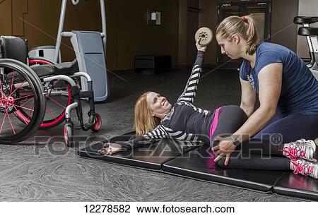 Physiotherapist assisting young woman with spinal cord injury in performing upper body windshield wipers, weighted oblique twists exercises; Edmonton, Alberta, Canada View Large Photo Image Stock Image - Physiotherapist assisting young woman with spinal cord injury in performing upper body windshield wipers, weighted oblique twists exercises; Edmonton, Alberta, Canada. Fotosearch