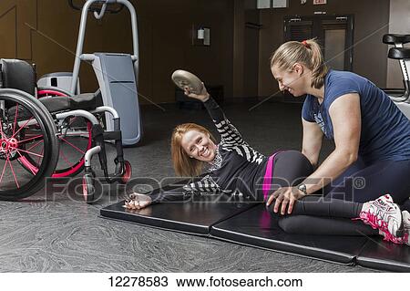 Physiotherapist assisting young woman with spinal cord injury in performing upper body windshield wipers, weighted oblique twists exercises; Edmonton, Alberta, Canada View Large Photo Image Stock Image - Physiotherapist assisting young woman with spinal cord injury in performing upper body windshield wipers, weighted oblique twists exercises; Edmonton, Alberta, Canada. Fotosearch