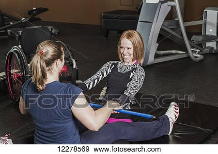 Physiotherapist assisting young woman with spinal cord injury in performing back extension exercises; Edmonton, Alberta, Canada View Large Photo Image Stock Photo - Physiotherapist assisting young woman with spinal cord injury in performing back extension exercises; Edmonton, Alberta, Canada. Fotosearch