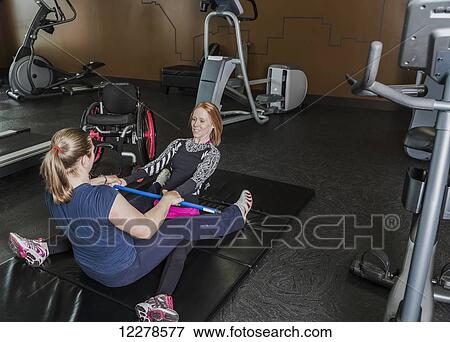 Physiotherapist assisting young woman with spinal cord injury in performing back extension exercises; Edmonton, Alberta, Canada View Large Photo Image Stock Photo - Physiotherapist assisting young woman with spinal cord injury in performing back extension exercises; Edmonton, Alberta, Canada. Fotosearch