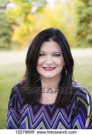 Portrait of a beautiful mature woman outdoors in a city park in autumn; St. Albert, Alberta, Canada View Large Photo Image Stock Photo - Portrait of a beautiful mature woman outdoors in a city park in autumn; St. Albert, Alberta, Canada. Fotosearch