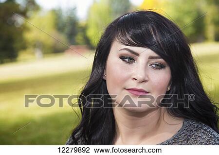 Stock Image - Portrait of a beautiful young woman outdoors in a park in autumn; St. Albert, Alberta, Canada. Fotosearch