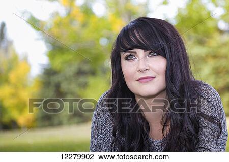 Stock Image - Portrait of a beautiful young woman outdoors in a city park in autumn; St. Albert, Alberta, Canada. Fotosearch