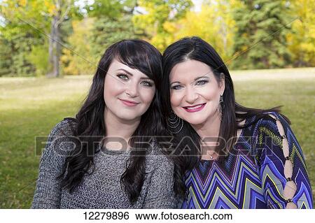 Stock Photograph - Portrait of a mother and daughter spending quality time together outdoors in a city park in autumn; St. Albert, Alberta, Canada. Fotosearch