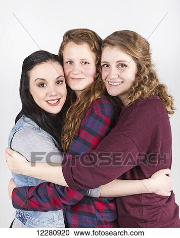 Portrait of three young women hugging each other, on a white background; Alberta, Canada View Large Photo Image Stock Image - Portrait of three young women hugging each other, on a white background; Alberta, Canada. Fotosearch