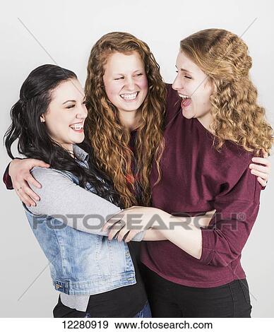 Portrait of three young women hugging each other, on a white background; Alberta, Canada View Large Photo Image Stock Photo - Portrait of three young women hugging each other, on a white background; Alberta, Canada. Fotosearch