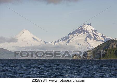 Shishaldin Volcano And Isanotski Peaks In The Background Of The Rugged Cliff Shoreline Of Cape Pankof On Unimak Island, Eastern Aleutian Islands; Southwestern Alaska, United States Of America View Large Photo Image Picture - Shishaldin Volcano And Isanotski Peaks In The Background Of The Rugged Cliff Shoreline Of Cape Pankof On Unimak Island, Eastern Aleutian Islands; Southwestern Alaska, United States Of America. Fotosearch