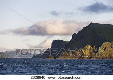 Shishaldin Volcano And Isanotski Peaks In The Background Of The Rugged Cliff Shoreline Of Cape Pankof On Unimak Island, Eastern Aleutian Islands; Southwestern Alaska, United States Of America View Large Photo Image Stock Image - Shishaldin Volcano And Isanotski Peaks In The Background Of The Rugged Cliff Shoreline Of Cape Pankof On Unimak Island, Eastern Aleutian Islands; Southwestern Alaska, United States Of America. Fotosearch