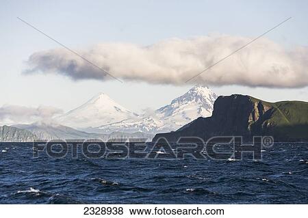 Shishaldin Volcano And Isanotski Peaks In The Background Of The Rugged Cliff Shoreline Of Cape Pankof On Unimak Island, Eastern Aleutian Islands; Southwestern Alaska, United States Of America View Large Photo Image Stock Photo - Shishaldin Volcano And Isanotski Peaks In The Background Of The Rugged Cliff Shoreline Of Cape Pankof On Unimak Island, Eastern Aleutian Islands; Southwestern Alaska, United States Of America. Fotosearch