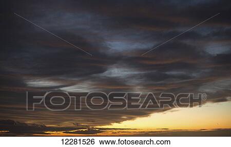 Storm clouds at sunset with a glowing golden horizon; Caloundra, Queensland, Australia View Large Photo Image Stock Photograph - Storm clouds at sunset with a glowing golden horizon; Caloundra, Queensland, Australia. Fotosearch