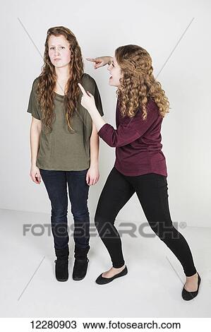 Studio shot of one friend making fun of another friend; Alberta, Canada View Large Photo Image Stock Image - Studio shot of one friend making fun of another friend; Alberta, Canada. Fotosearch