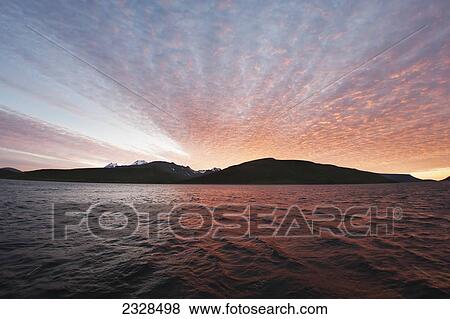 Sunset Behind A Ridgeline From The Water Near Cold Bay; Southwest Alaska, United States Of America View Large Photo Image Stock Photo - Sunset Behind A Ridgeline From The Water Near Cold Bay; Southwest Alaska, United States Of America. Fotosearch