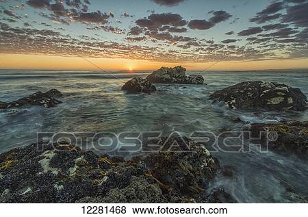 Stock Photo - Sunset over the ocean at Marble Beach, Namakwaland National Park; South Africa. Fotosearch