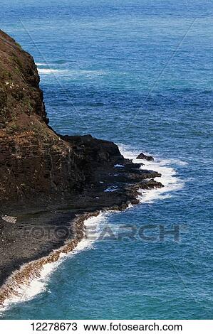 Stock Image - Surf along the Kilauea cliffs; Kilauea, Kauai, Hawaii, United States of America. Fotosearch