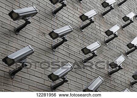 Stock Photograph - The wall of a building fully covered by monitoring cameras; Toronto, Ontario, Canada. Fotosearch