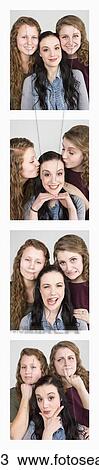 Stock Image - Three young women creating photo booth series of images in filmstrip format; Alberta, Canada. Fotosearch