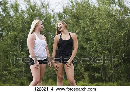 Two teenage girlfriends walking and talking together in a park; Edmonton, Alberta, Canada View Large Photo Image Picture - Two teenage girlfriends walking and talking together in a park; Edmonton, Alberta, Canada. Fotosearch