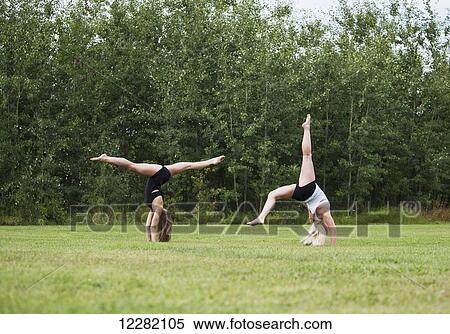 Stock Photography - Two teenage gymnasts practicing their routines outdoors in a park; Edmonton, Alberta, Canada. Fotosearch