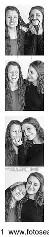 Stock Image - Two young women creating photo booth series of images in filmstrip format; Alberta, Canada. Fotosearch