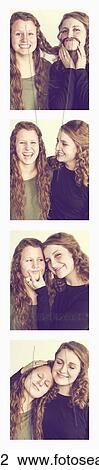 Stock Image - Two young women creating photo booth series of images in filmstrip format; Alberta, Canada. Fotosearch