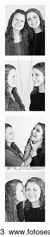 Stock Image - Two young women creating photo booth series of images in filmstrip format; Alberta, Canada. Fotosearch