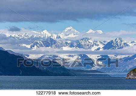 View of the snow capped Fairweather Mountain Range from Glacier Bay National Park, Southeast Alaska, Summer View Large Photo Image Stock Photo - View of the snow capped Fairweather Mountain Range from Glacier Bay National Park, Southeast Alaska, Summer. Fotosearch