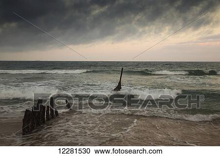 Stock Image - Waves breaking near the shore at sunset; Dicky Beach, Queensland, Australia. Fotosearch